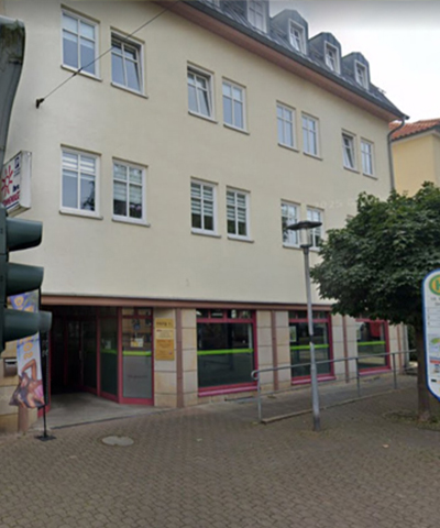 Außenansicht des Standorts und Pflegebüros des ambulanten Pflegedienstes PflegeEngel in Gotha mit Bushaltestelle vor dem Gebäude